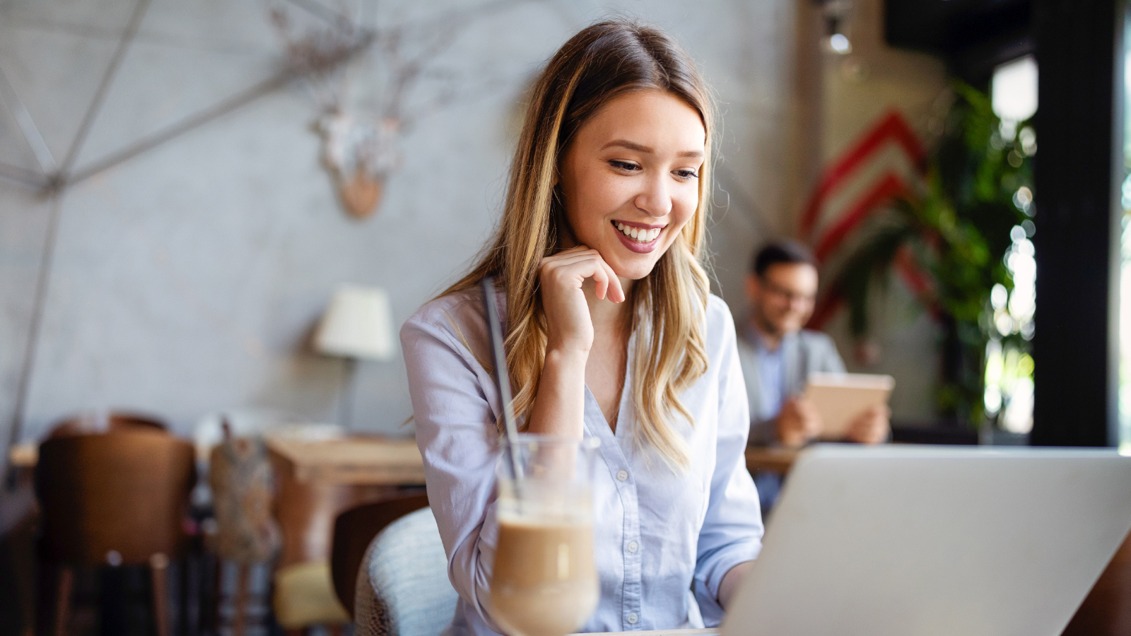 business woman in cafe looking at online banking on computer