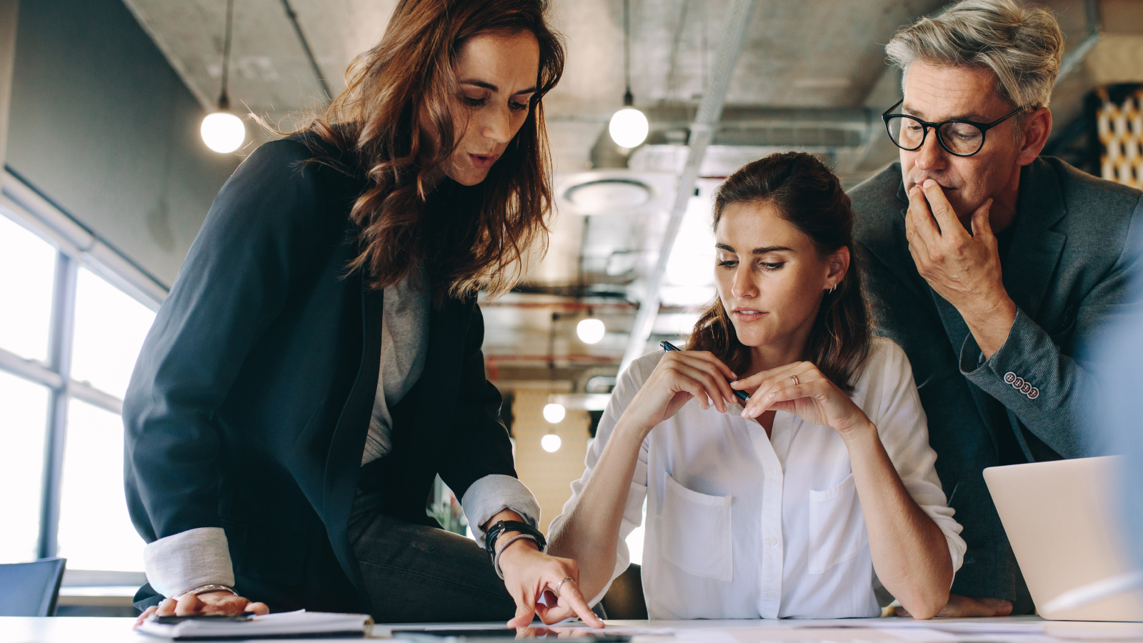 three business team members looking at plans