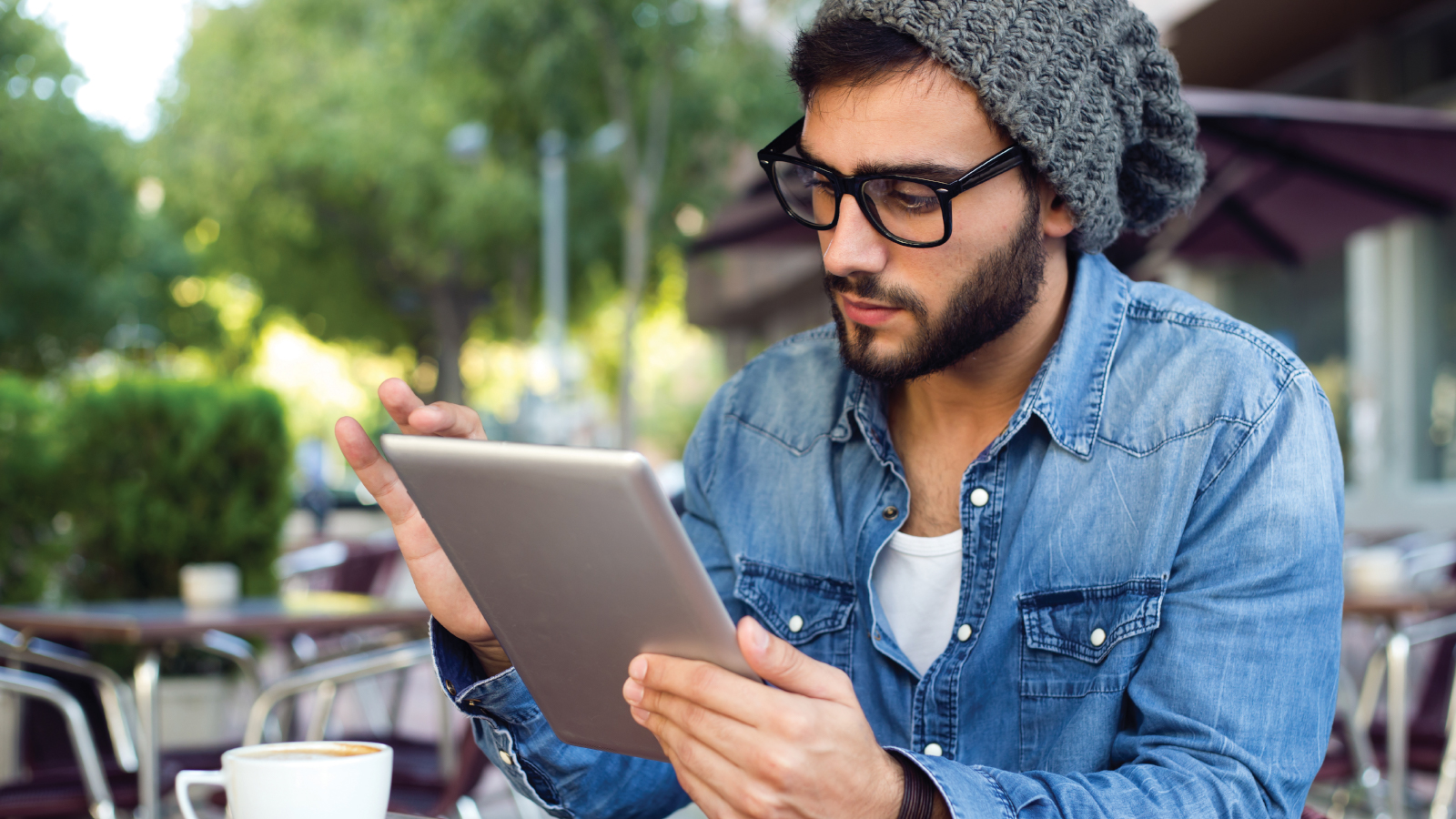 Man enjoying coffee while checking his account on a tablet