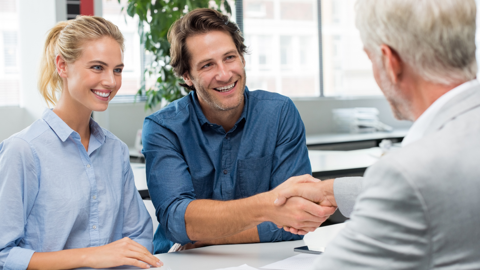 couple shaking hands with an experienced closing agent