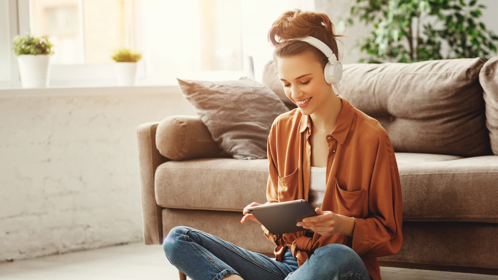 girl sitting in front of couch looking at tablet