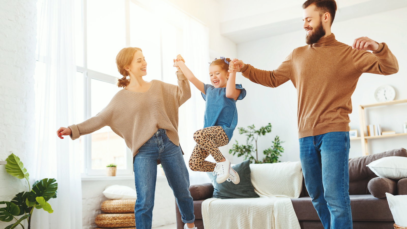 mom and dad pick up daugher and swing her in the air