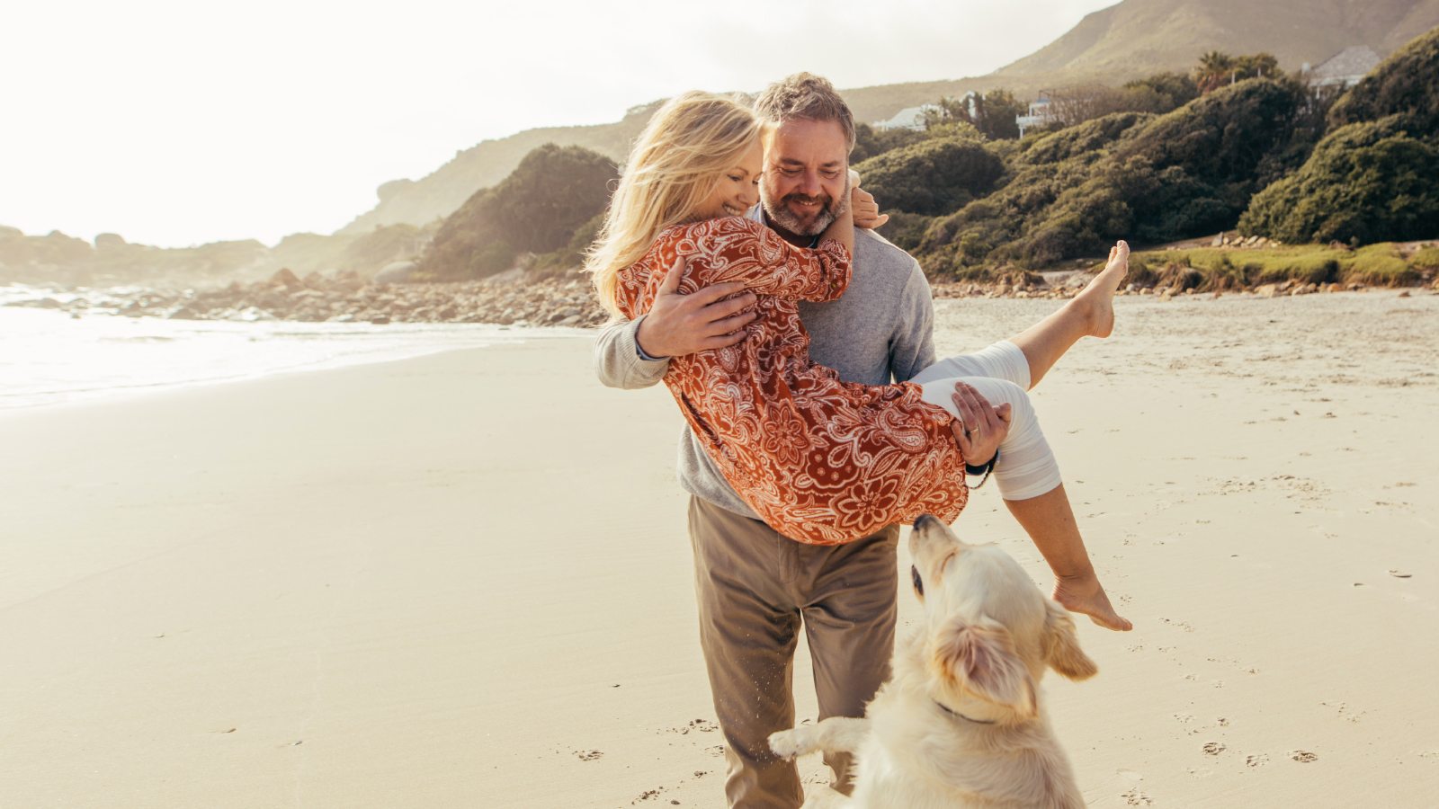 Couple at the beach with their dog.