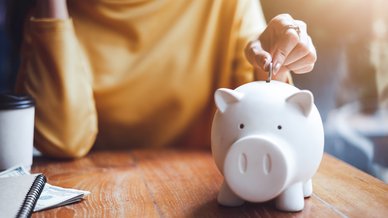 woman putting coin in piggy bank