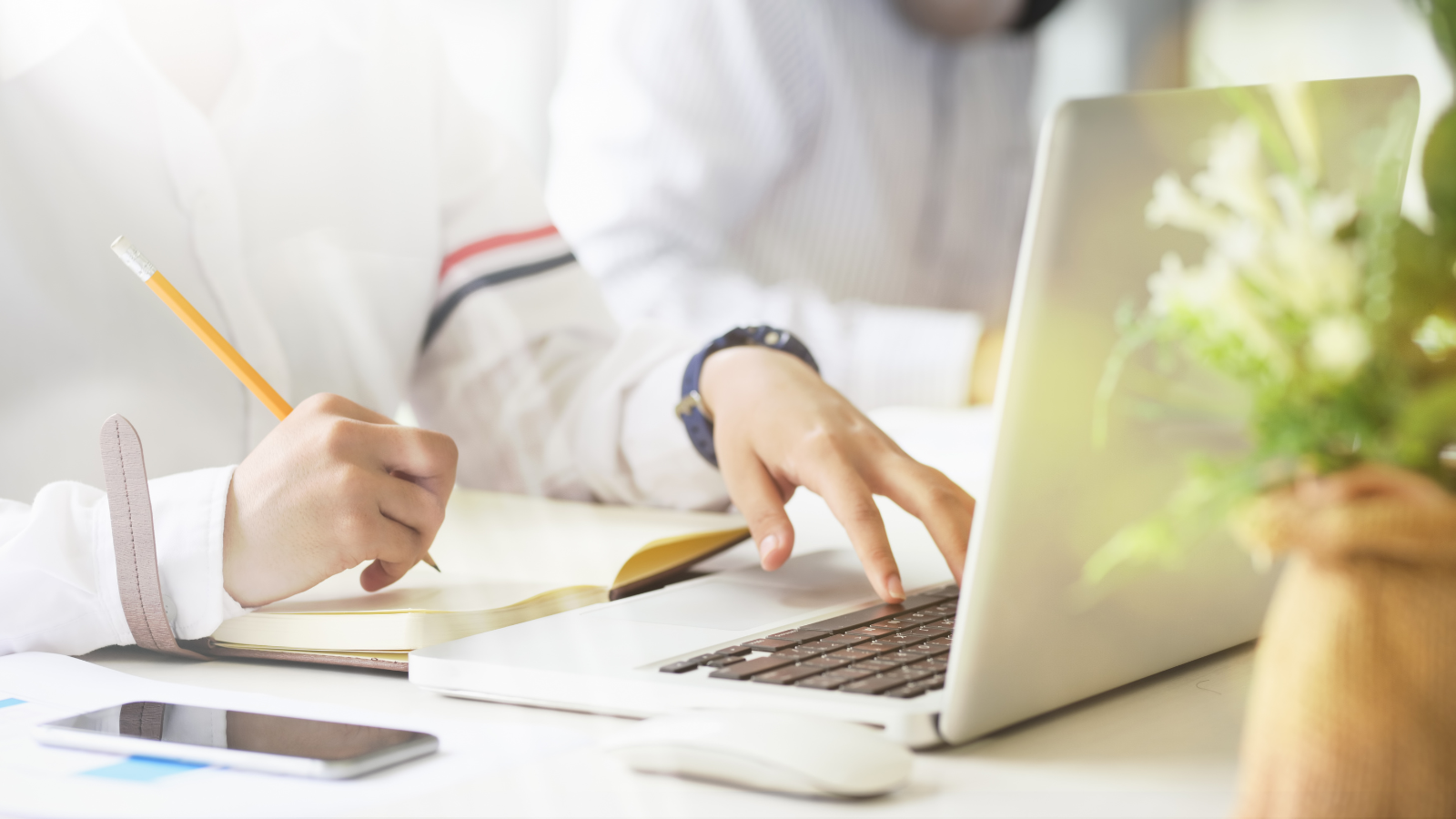 person on laptop with notebook